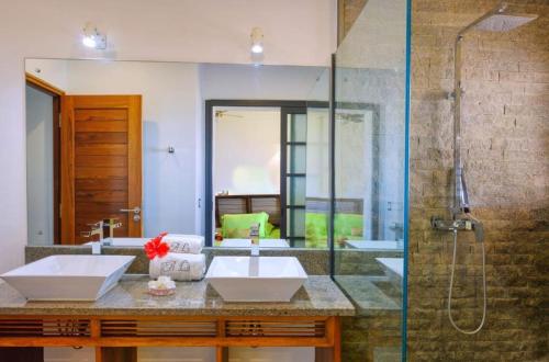 贝岛ANJARA LODGE Villa de 3 chambres的一间带两个盥洗盆和淋浴的浴室