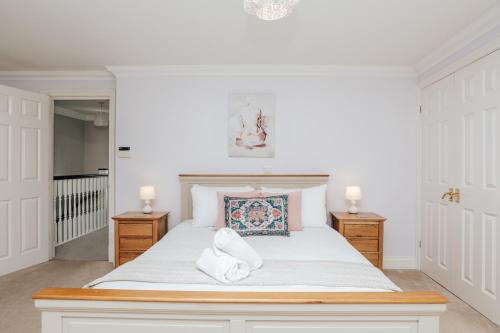 亨利昂泰晤士Olive Tale的一间卧室配有一张带两盏灯的大型白色床。
