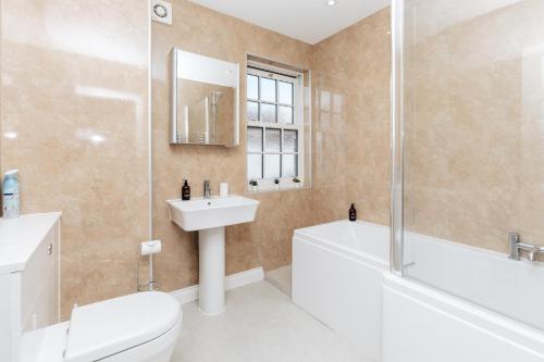 亨利昂泰晤士Olive Tale的浴室配有卫生间、盥洗盆和浴缸。