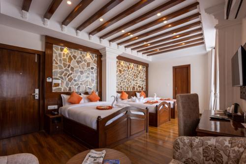 加德满都Airport Himalaya Boutique Hotel的一间带两张床的卧室和一间客厅