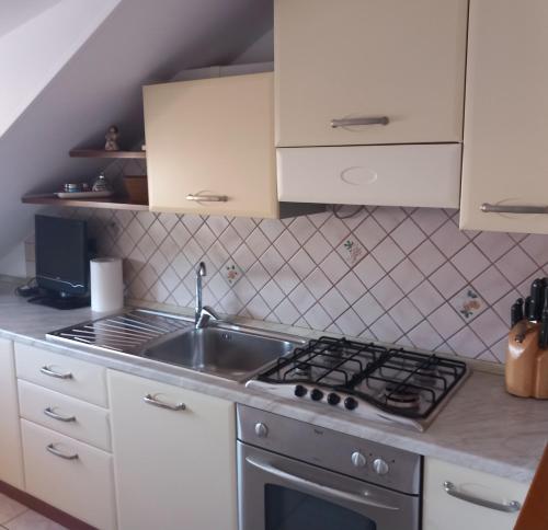 卡斯特尔迪拉马Romano's House的厨房配有水槽和炉灶