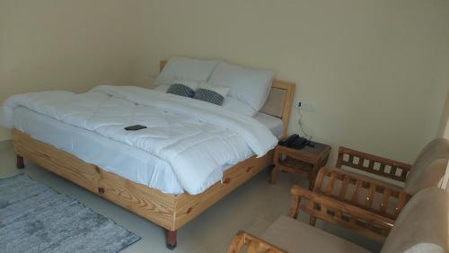 PhataHotel Anandam phata的卧室配有一张带白色床单和枕头的大床。