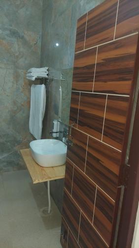 PhataHotel Anandam phata的一间带水槽和木墙的浴室