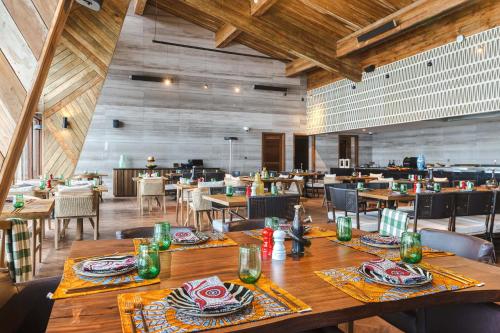 恩戈罗恩戈罗Ngorongoro Lodge member of Meliá Collection的用餐室配有木桌和椅子
