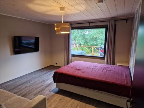 耶姆赛Tuorilan tupa的一间卧室设有红色的床和大窗户