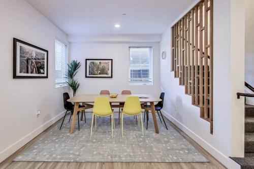 奥克兰Fully-Stocked Studio Suite的一间带桌子和黄色椅子的用餐室