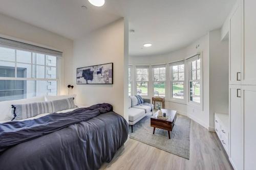 奥克兰Luxury Furnished Studio Suite in Lake Merritt的一间卧室配有一张床、一张沙发和窗户。
