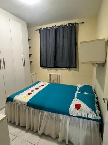 贝伦Apartamento em condomínio Belém的一间卧室配有一张带蓝色床单的床和一扇窗户。