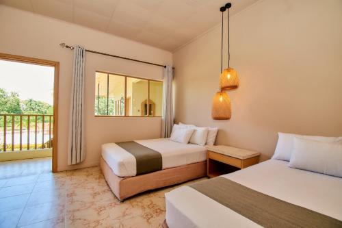 圣菲德安蒂奥基亚Hotel La Iguana de Santa fe De Antioquia的酒店客房设有两张床和一个阳台。