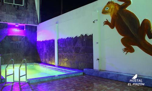 阿约拉港Hostal El Pinzón的墙上画有恐龙的游泳池