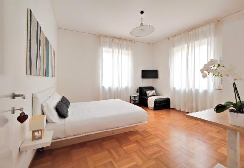 维罗纳Corte Melone room rental的白色卧室配有床和椅子