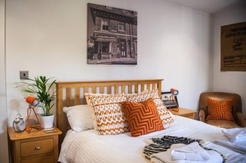 阿宾汉姆Sam's Place Apartment in Uppingham, Rutland的卧室配有带枕头的床铺,墙上挂着一幅画