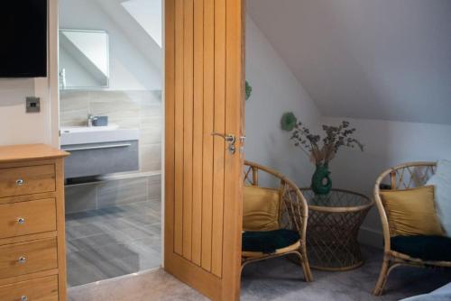 阿宾汉姆Sam's Place Apartment in Uppingham, Rutland的通往卧室的门,卧室配有水槽和椅子