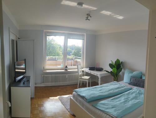 KronshagenFerienwohnung in Kronshagen Monteurwohnung 3 Zimmer 70 m2, Küche und Badezimmer的一间卧室配有一张床、一张书桌和一个窗户。