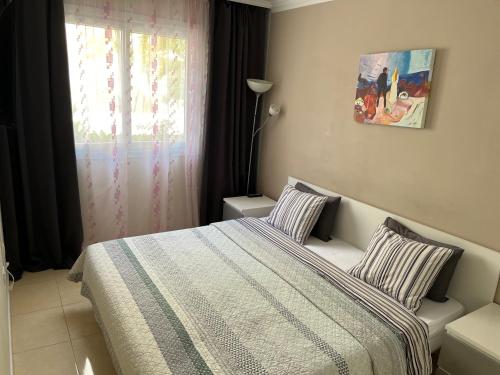 阿布里斯Brisas del Mar的一间卧室配有一张带条纹毯子的床和窗户