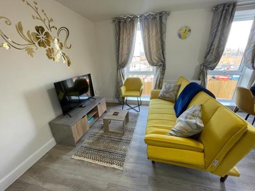 米尔顿凯恩斯Spacious Apartment in Brooklands的客厅设有黄色沙发和电视