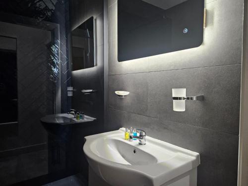 布雷得佛Centenary Apartments的浴室设有白色水槽和镜子