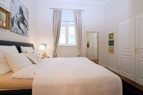 布拉迪斯拉发Hidden gem - Cozy quiet 2BR apt in city center的卧室设有一张白色大床和一扇窗户。