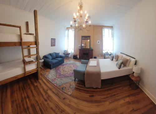 克拉克斯代尔HOSTEL Auberge Clarksdale的一间卧室配有一张床、一张沙发和一个吊灯。