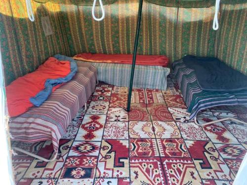 杜兹Private Camp25km-from DOUZ的一间设有两张床的房间和一张地毯