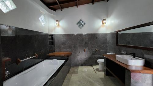 武吉拉旺Sam's Bungalows的带浴缸和盥洗盆的浴室