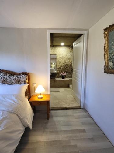 Couze-et-Saint-FrontAirbnb: Vieilles Pierres et Rivière en Périgord的一间卧室配有一张床和一张带台灯的桌子