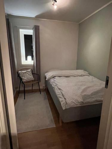 特罗姆瑟Lykkebo的卧室配有床、椅子和窗户。