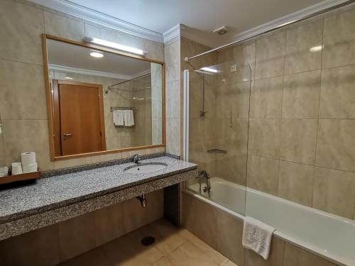 塞洛里库达贝拉金塔多斯赛德鲁斯酒店的一间带水槽、浴缸和镜子的浴室