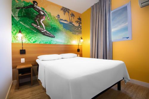 圣卡洛斯Hotel Dan Inn São Carlos的一间卧室配有一张床,画着冲浪者