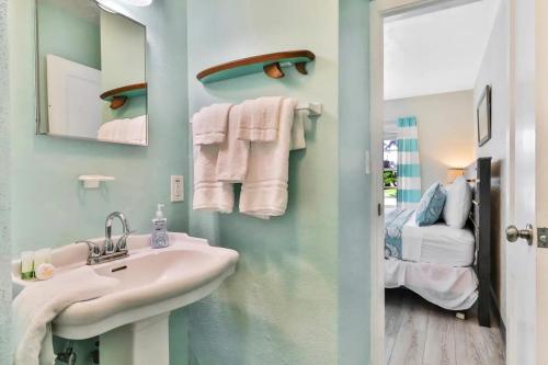 克利尔沃特Pelican Beach Studio #6的一间带水槽和镜子的浴室以及一张床