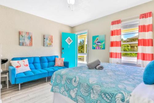 克利尔沃特Pelican Beach Studio #6的一间卧室配有蓝色的床和蓝色的沙发