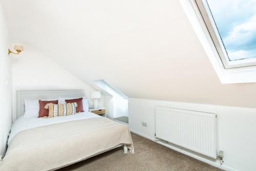 HanwellSpacious en-suite in a 5-Bedroom House at Hanwell (2nd Floor)的白色的卧室设有床和窗户