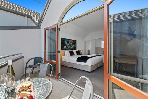 陶波Taupo Central Apartment的一间卧室配有一张床,阳台配有桌子
