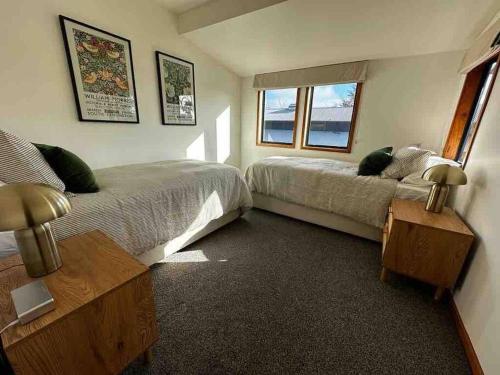 北哈夫洛克Woolshed 17 - Self Catering Accommodation的一间卧室设有两张床和窗户。