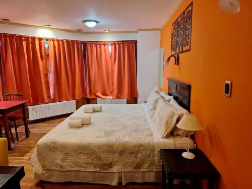 本塔纳山村Grand Hotel - Sierra De La Ventana的一间卧室配有一张带橙色墙壁的大床