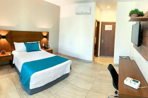 瓜伊马斯los rafeles 5的酒店客房配有一张床、一张书桌和一台电视。