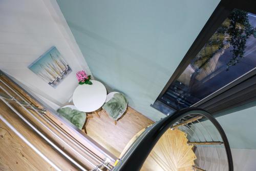 考文垂A101 Comfy Stylish Loft的白色桌子和花卉白色花瓶的楼梯