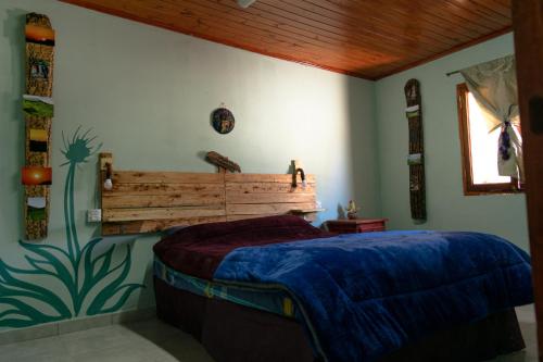 乌玛瓦卡Acusi Hostel Camping的一间卧室配有一张带木制床头板的床