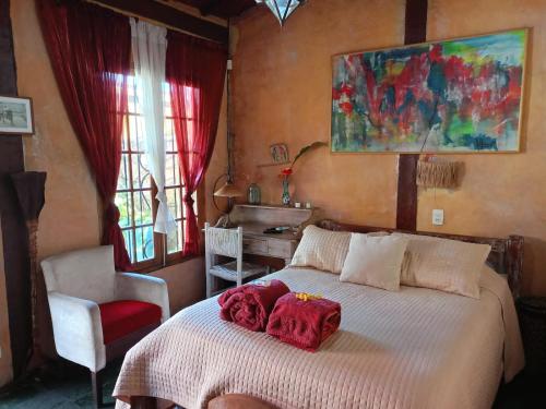 伊利亚贝拉Vila Santa Rosa的一间卧室配有一张带红色毛巾的床