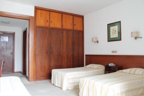 丰沙尔格雷科公寓酒店的酒店客房设有两张床和一个衣柜。