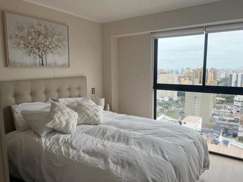 利马Aparment Deluxe San Isidro的卧室配有白色的床和大窗户