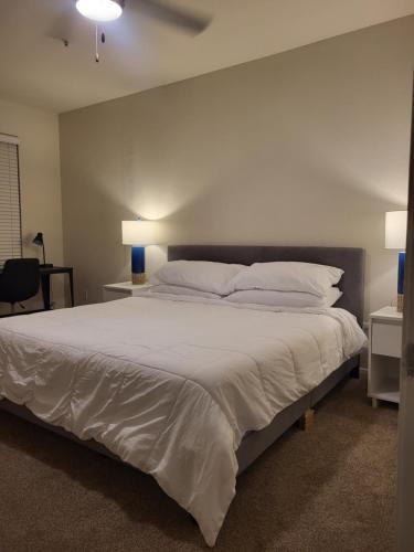 达拉斯Downtown Dallas 2bd free parking的卧室配有一张带白色床单和枕头的大床。