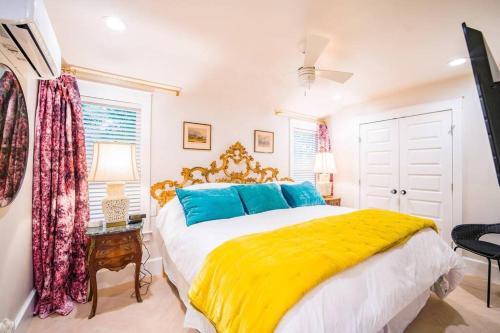 卡尔曼SweetSuiteCullman-couples retreat tiny home dwntwn的一间卧室配有一张大床,提供黄色和蓝色的枕头