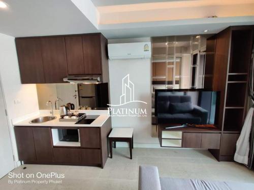 Ban Lum FuangSurin Beach The Aristo Condo 1的一个带水槽的厨房和一间客厅