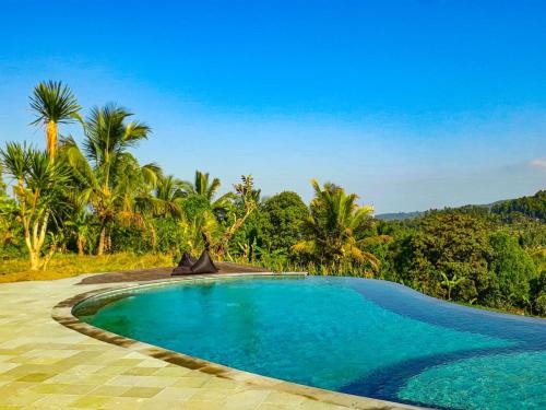 姆杜克乐颂餐厅酒店的棕榈树度假村内的游泳池
