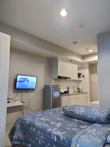 PulosirihGrand Kamala Lagoon Bekasi Apartement - Type Studio的一间卧室配有一张床和一台平面电视