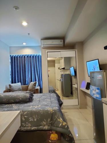 PulosirihGrand Kamala Lagoon Bekasi Apartement - Type Studio的客房设有床、沙发和镜子