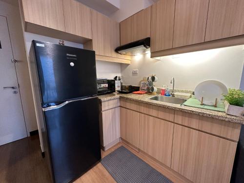 马尼拉CELANDINE Residence by DMCI的厨房配有黑色冰箱和水槽