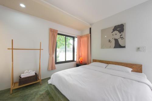 坤西育府Suptara Resort的白色的卧室设有一张大床和一个窗户