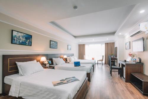 河内Ha Noi Lake View Hotel & Travel的酒店客房设有三张床和一张书桌